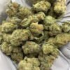 Grapes and Cream THCa Flower buds on a white background, showcasing dense, purple-hued nugs with a sweet, fruity aroma