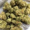 Honey Buns Exotic THCa Flower buds on a white background, showcasing dense, frosty nugs with a sweet aroma